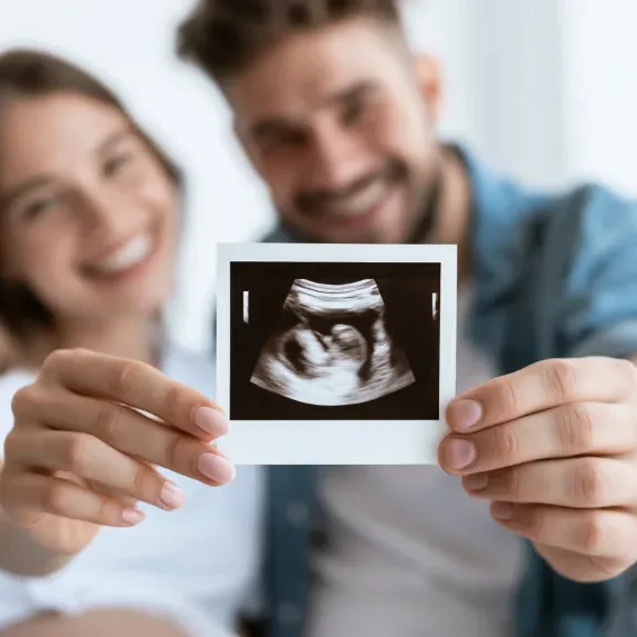 young couple holding ultrasound photo toward camera, happy pregnancy announcement atmosphere with soft indoor lighting and blurred background, airy atmosphere, wide negative space --ar 16:9 --seed 2801848490 --raw --profile 286piie --stylize 50 --hd --v 8.1 Job ID: 566ddda9-2a71-475c-b267-73b2f03a9255